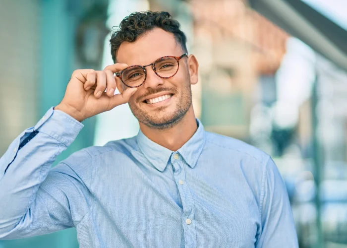 young-hispanic-businessman-smiling-happy-touching-his-glasses-city-min